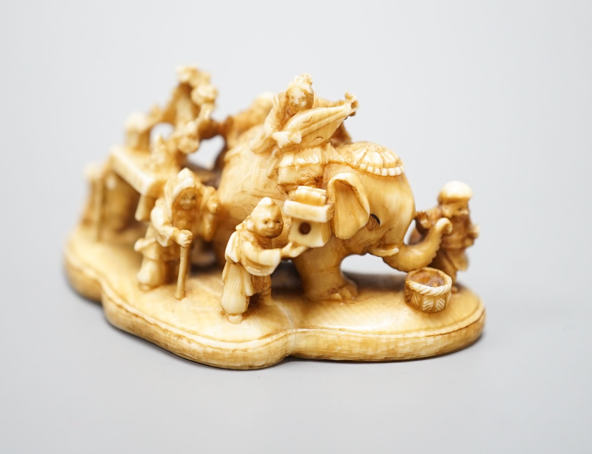 A Japanese carved ivory netsuke, mother of pearl inset to base with signature 'Gyokuzan', Meiji period, 6cm wide